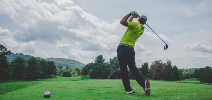 Golfista při provedení golfového švihu na hřišti