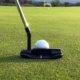 Putter a golfový míček na upraveném greenu