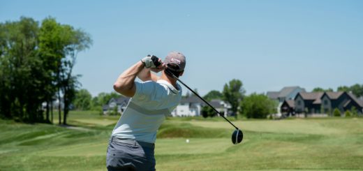 Golfista při dokončení úderu na hřišti