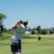 Golfista při dokončení úderu na hřišti